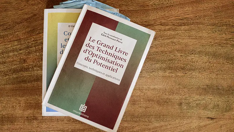 2 livres empilés sur une table en bois. Les livres parlent de développement mental et de sérénité